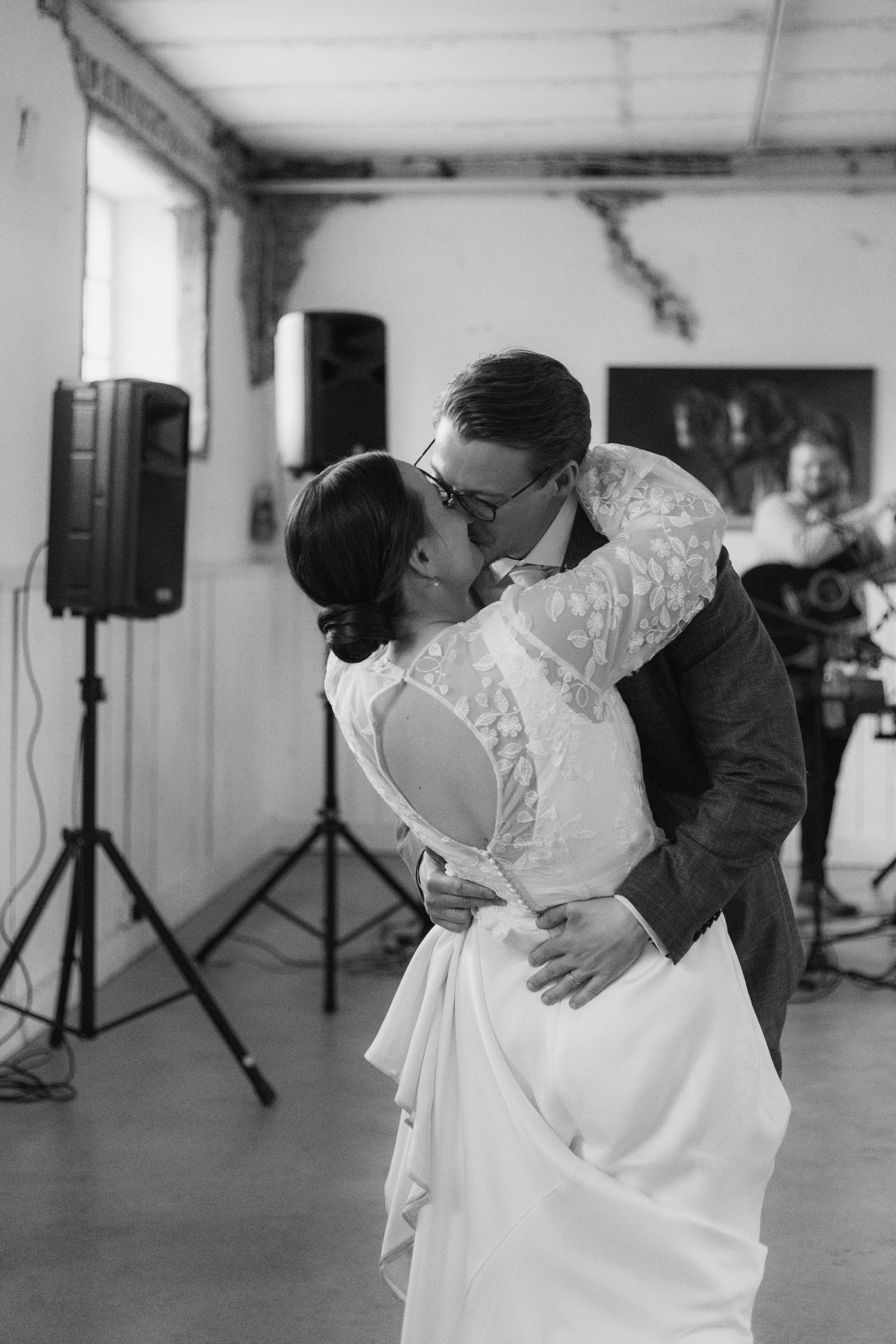 A romantic dance moment captured in black and white at an indoor venue.