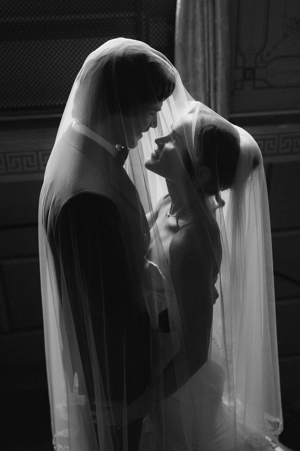 A series of romantic black and white wedding photos showing silhouettes of a couple behind a flowing veil.