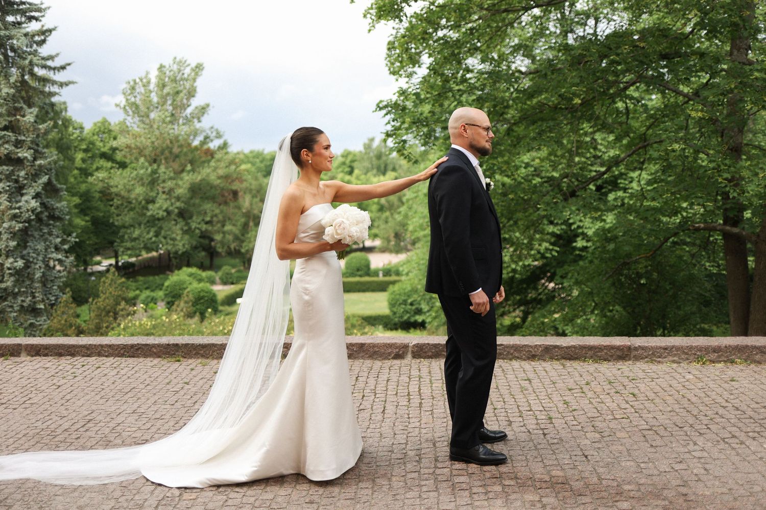 A bride taps her groom's shoulder for their first look moment on their wedding day.