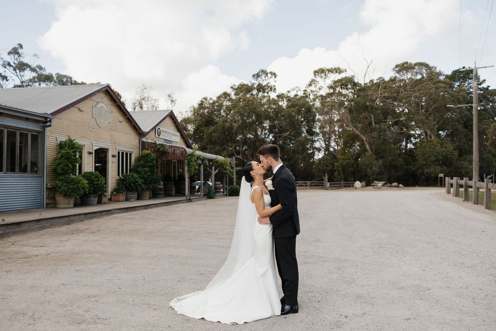 A couple shares a romantic moment during their wedding photoshoot at Merricks Store
