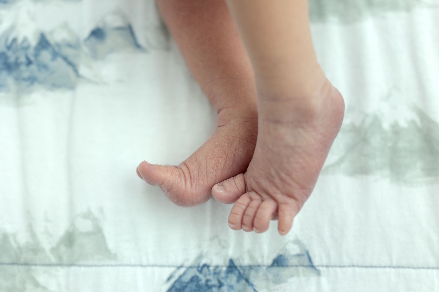 Close-up of baby feet touching feet
