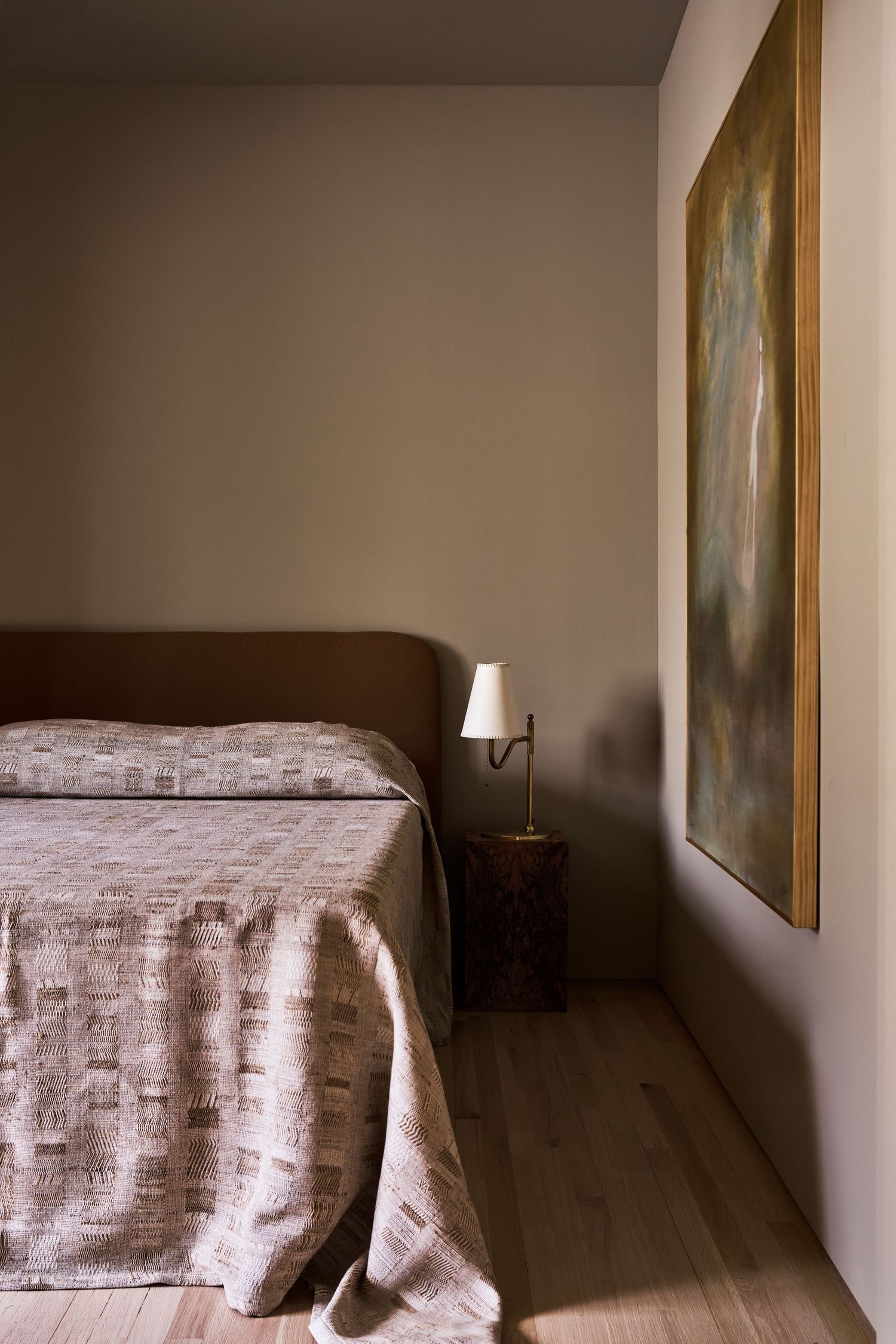 A series of minimalist bedroom photos showing a bed with textured beige bedding against neutral walls and artwork.