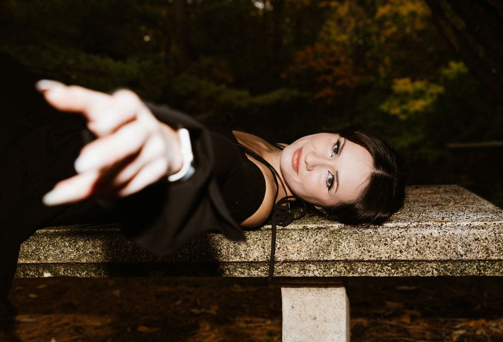 A person in elegant formal attire poses gracefully on stone steps during a romantic outdoor photo session.