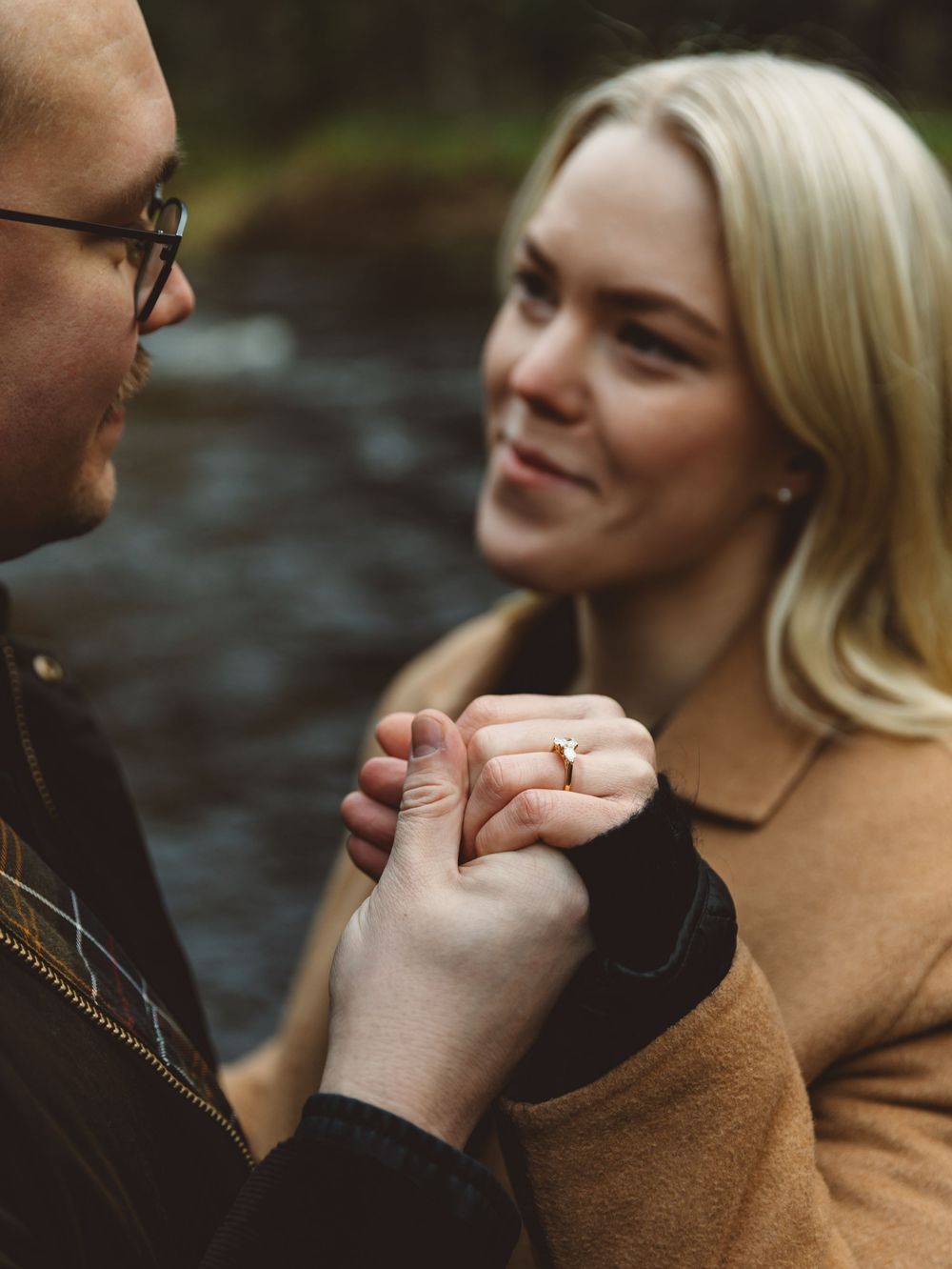 Close-up of hands holding during an intimate engagement moment.