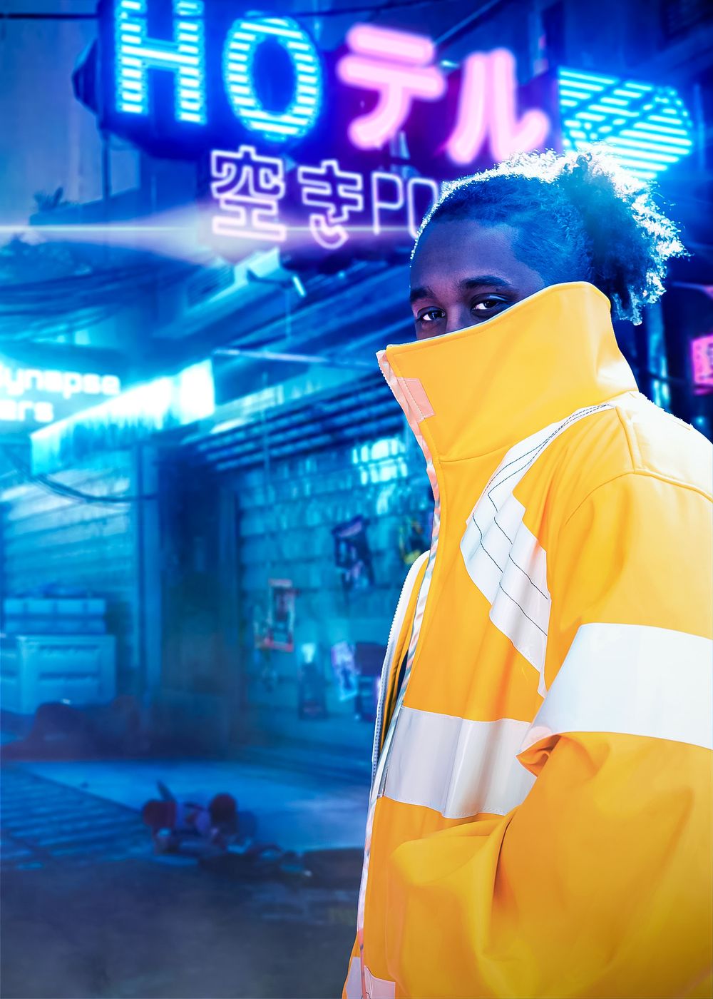 A man in a yellow reflective jacket poses against a neon-lit cyberpunk street with Japanese signs at night.