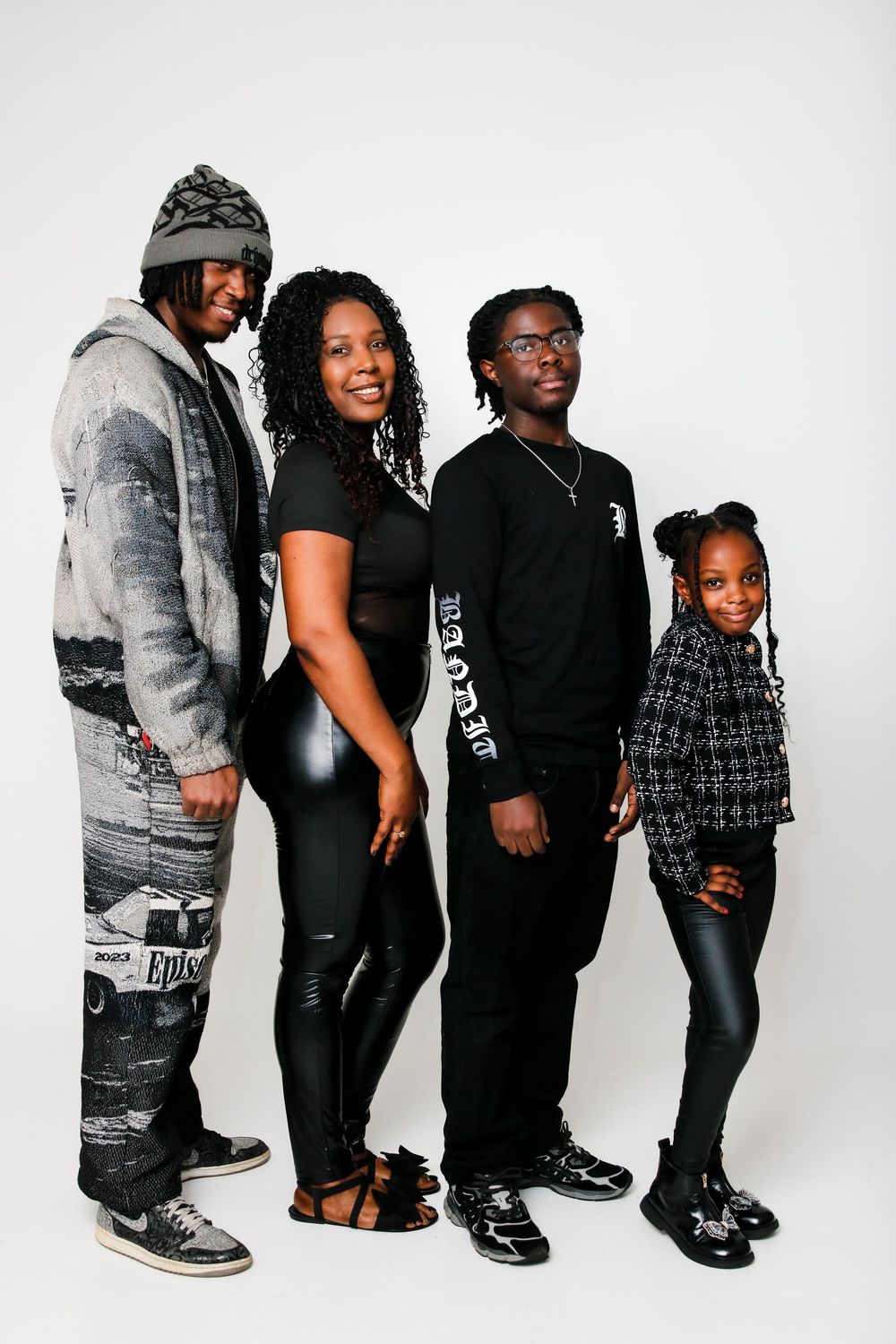 Group photo of people wearing casual black and gray outfits against white background.