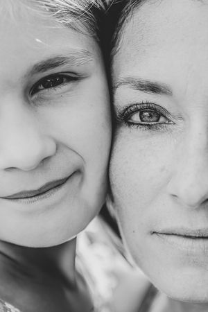 A black and white close-up montage of smiling faces and eyes creating an intimate emotional portrait.