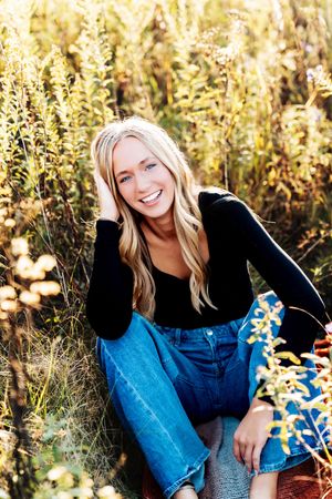 Candid outdoor portrait series in a natural setting with golden wildflowers and warm sunlight filtering through tall grass.