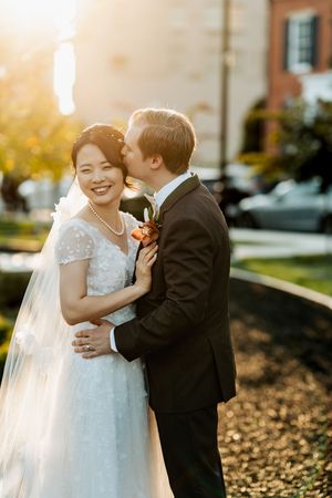 A bride and groom share a romantic moment outdoors during their autumn wedding photoshoot.