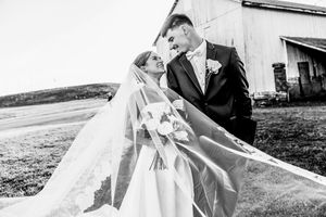 Black and white wedding photos show romantic moments between a couple outdoors in a natural setting.