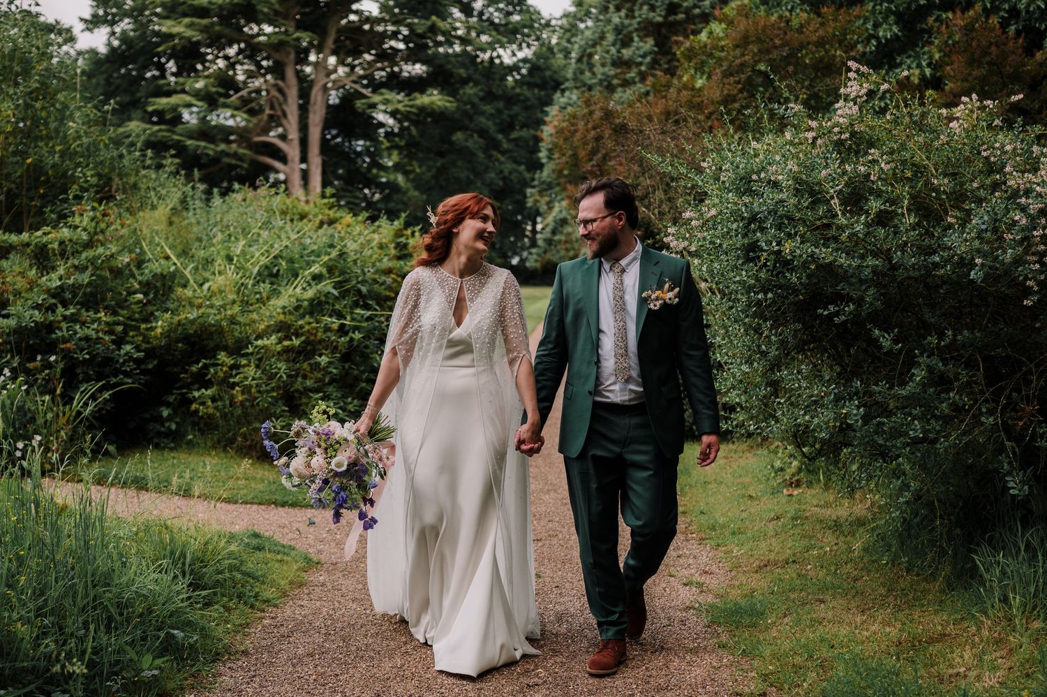 A joyful wedding moment captured with confetti falling as the newlyweds share a laugh outside.