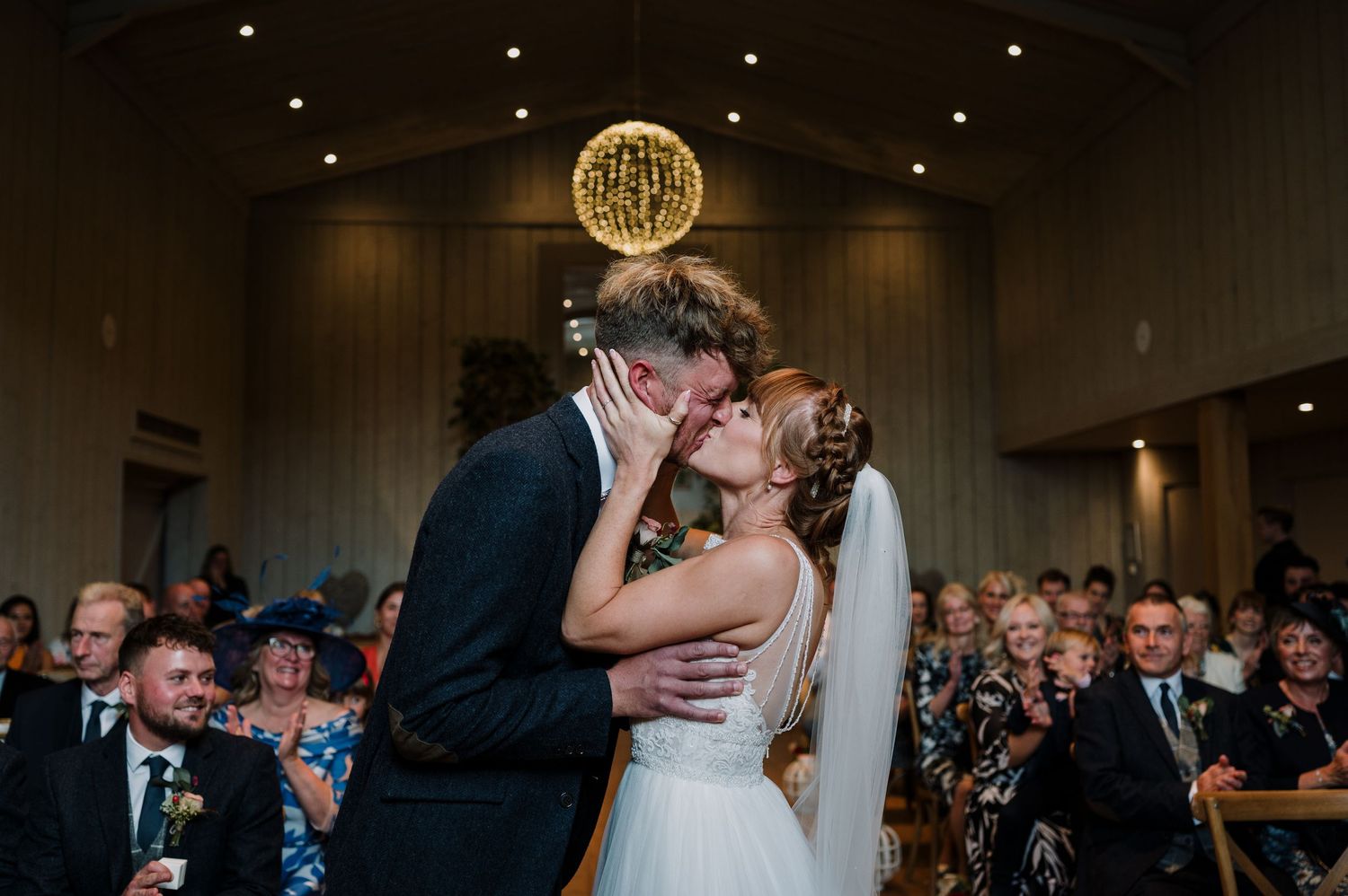 A joyful wedding moment captured with confetti falling as the newlyweds share a laugh outside.