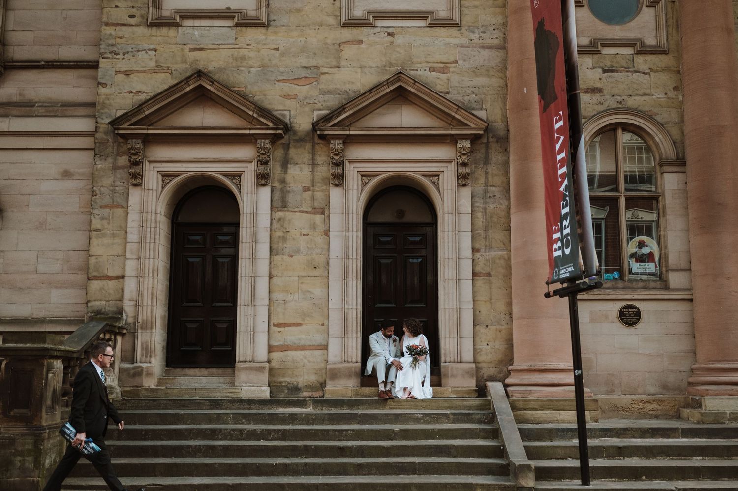 A joyful wedding moment captured with confetti falling as the newlyweds share a laugh outside.