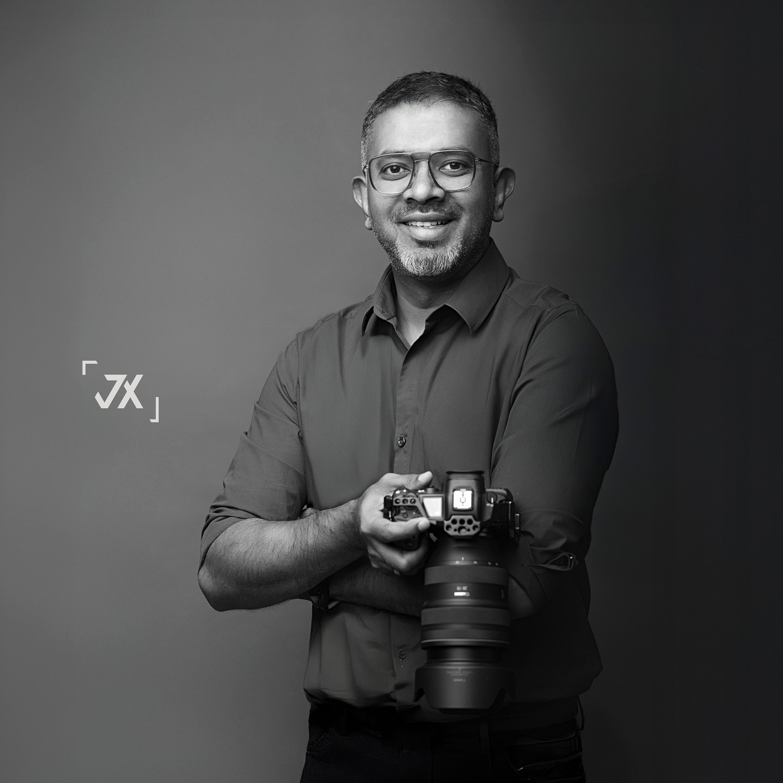 Photographer in casual attire holding professional lighting equipment on city street.