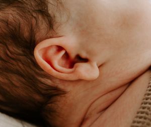 Close-up detail of baby's ear and soft skin.
