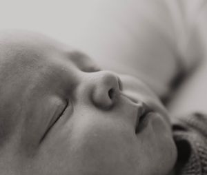 Close-up black and white portrait of a peaceful sleeping baby's face.