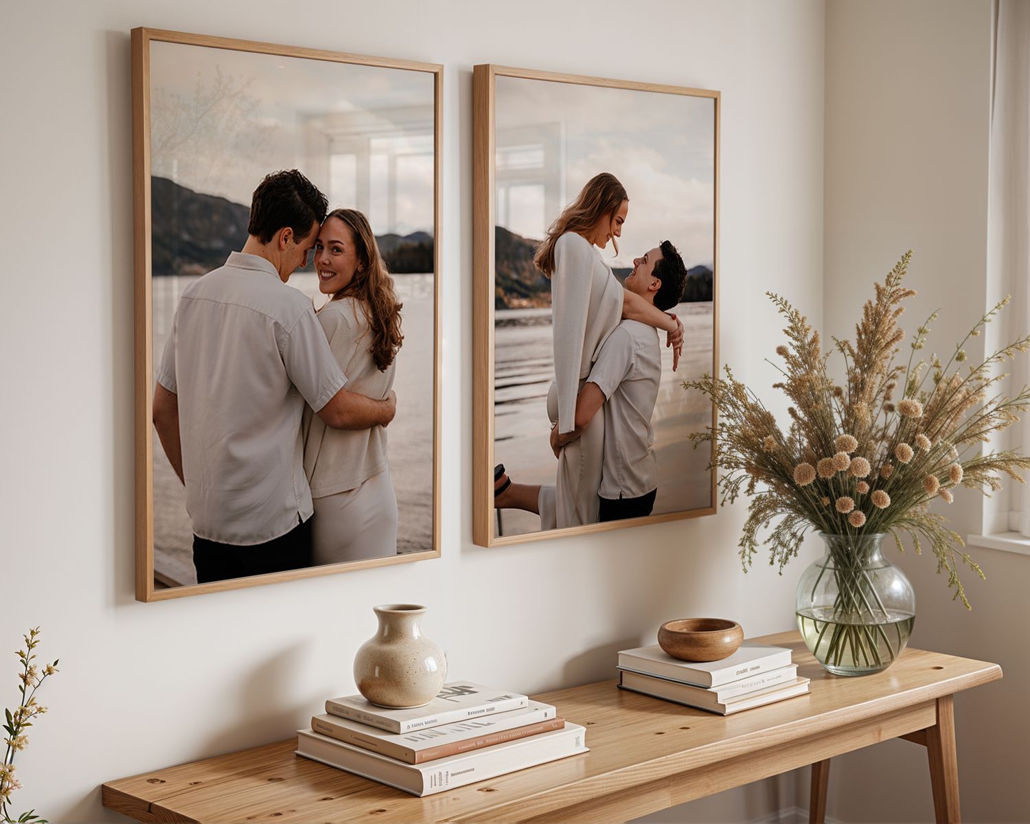 Modern coastal style entryway with framed artwork, wooden console table, pottery, and a delicate dried floral arrangement.