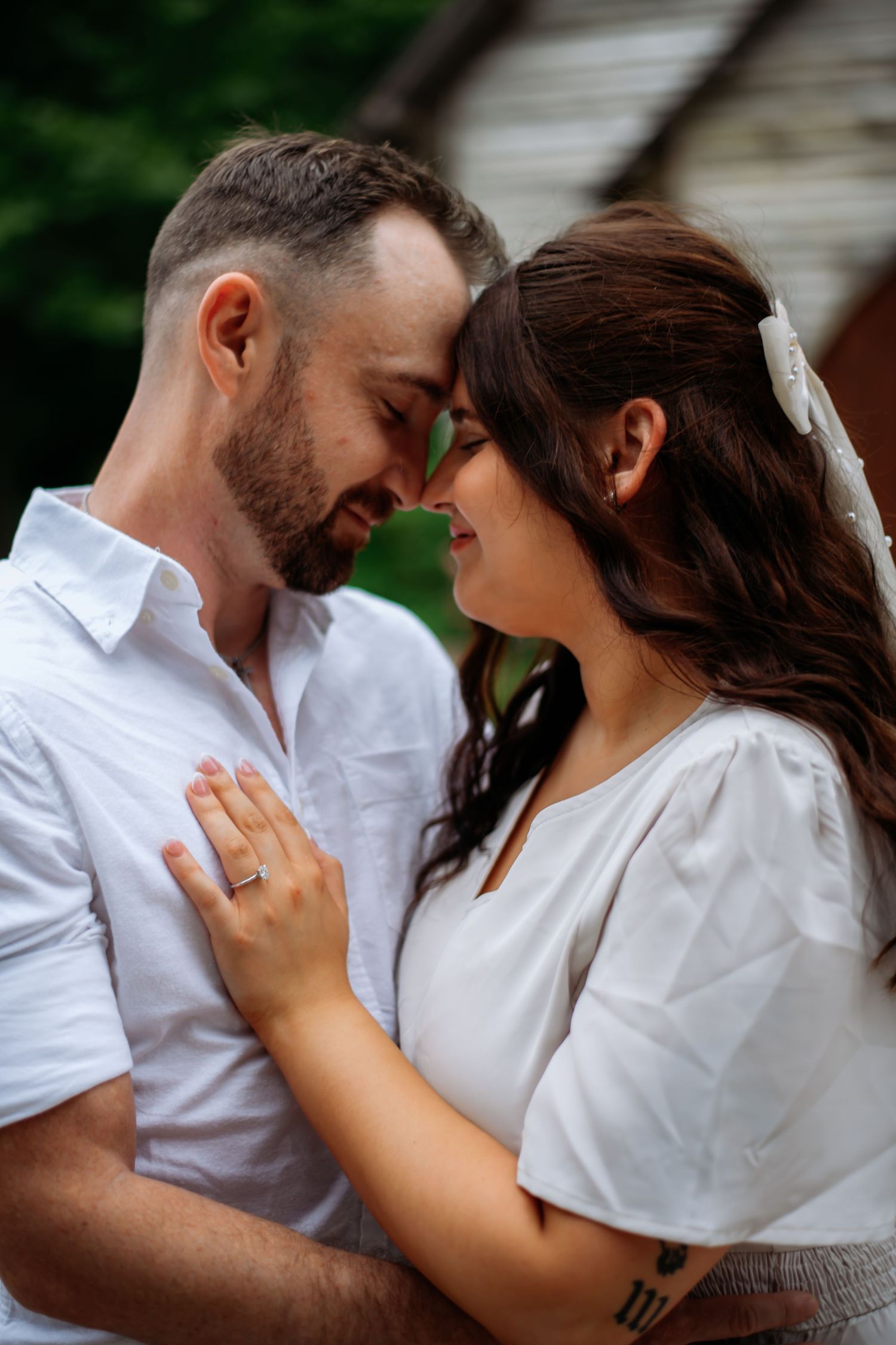 A romantic couple embraces while sharing a tender moment outdoors.