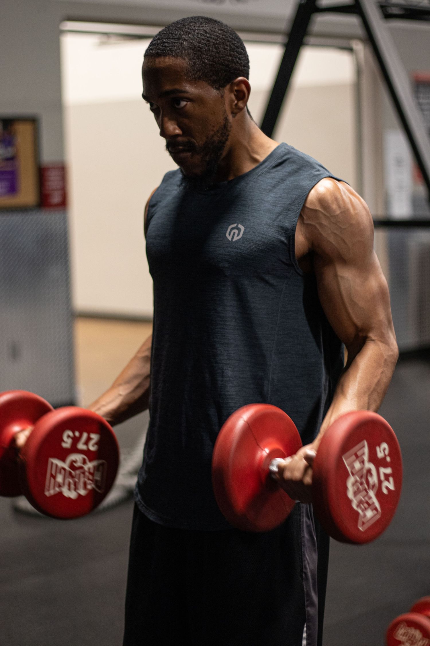 Fitness photography session in Long Beach gym showing athlete performing bicep curls by Justicee Photography