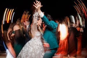 Wedding guests dancing and celebrating on a dimly lit dance floor with motion blur effects.