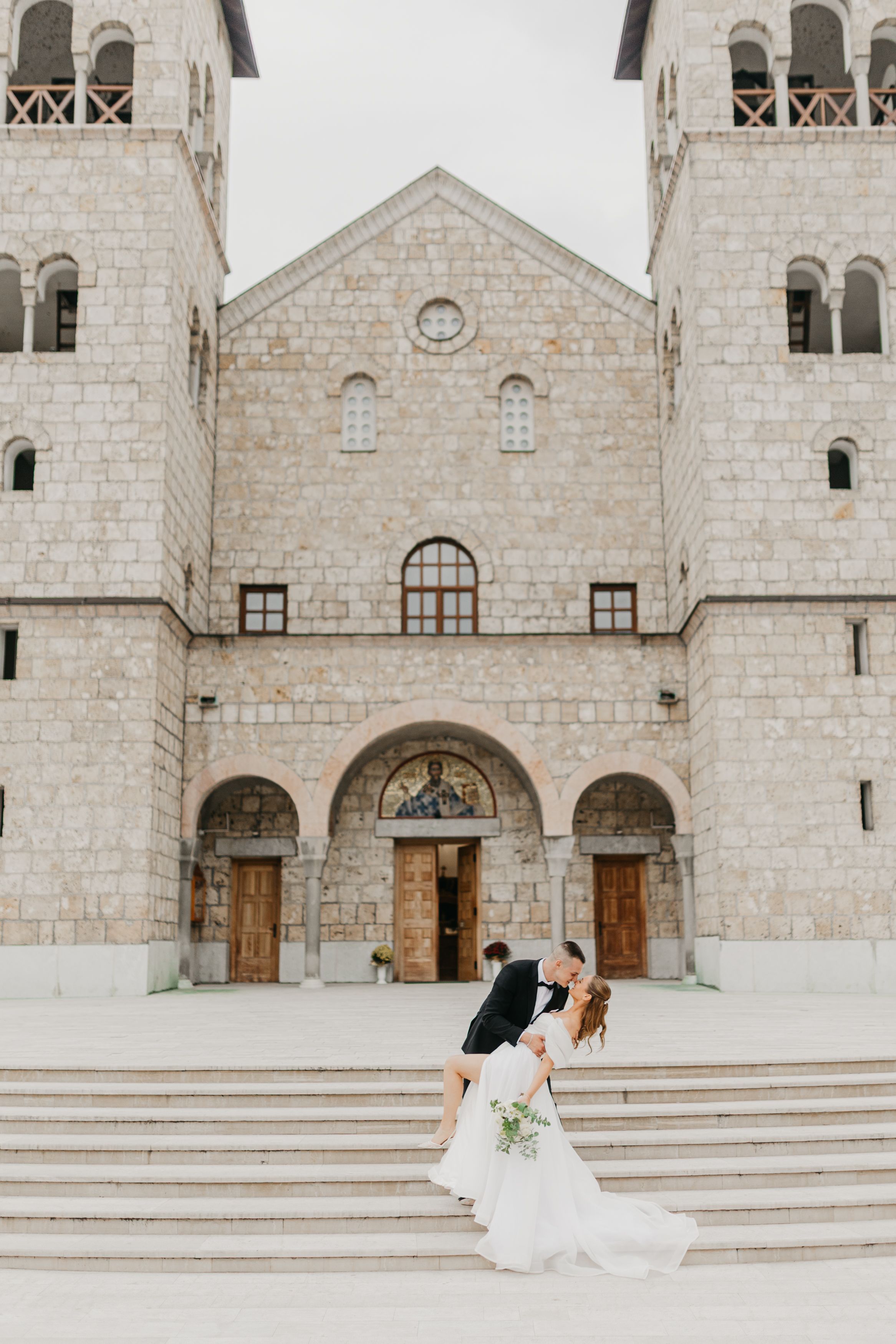 A series of architectural shots showing the exterior of a grand stone church with arched doorways and steps.