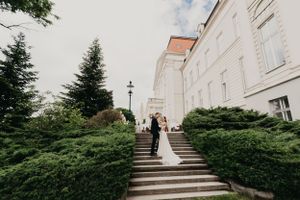 Classic wedding venue with stone staircase and evergreen landscaping.