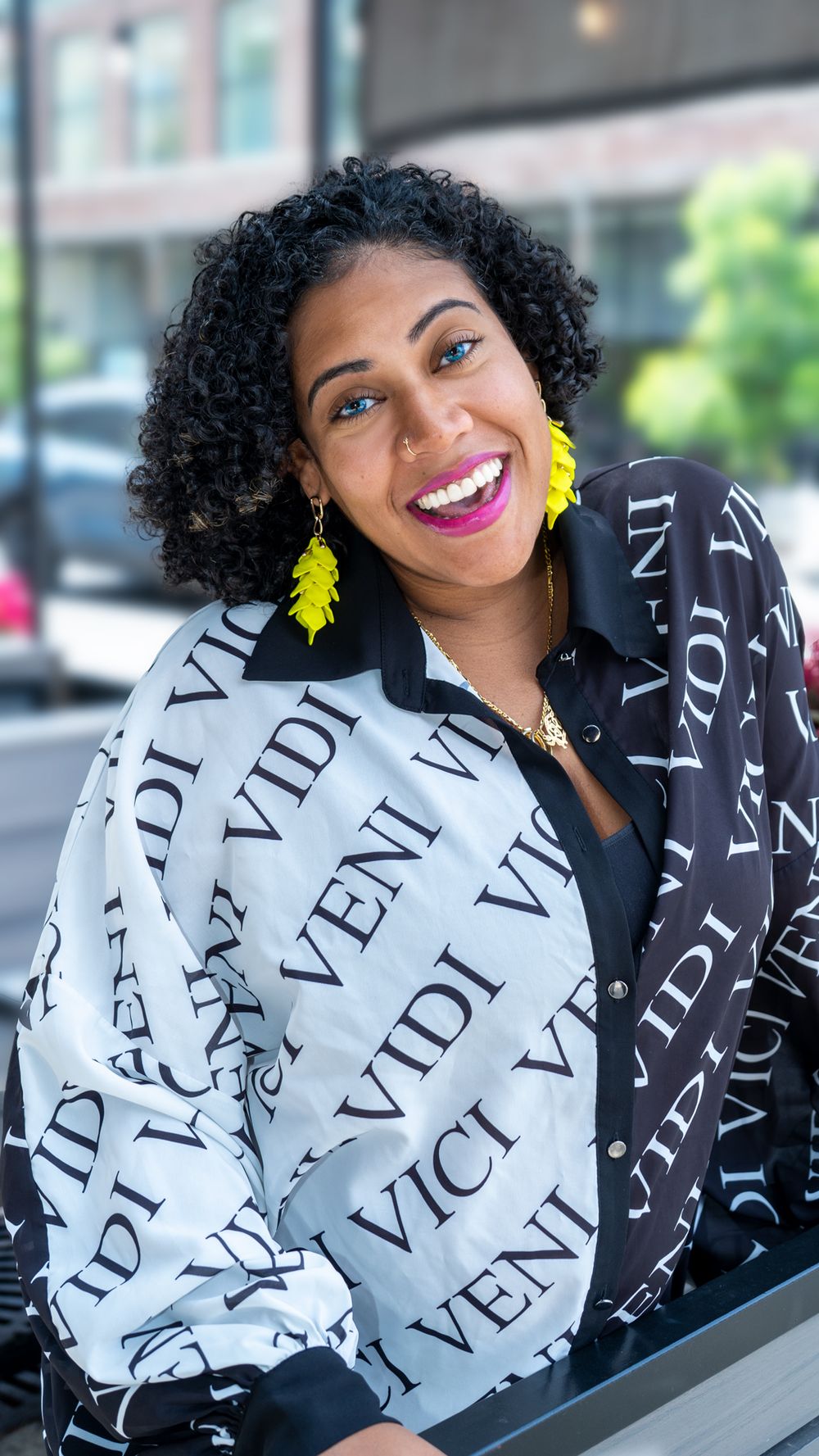 Stylish portrait in black and white patterned jacket with yellow earrings.