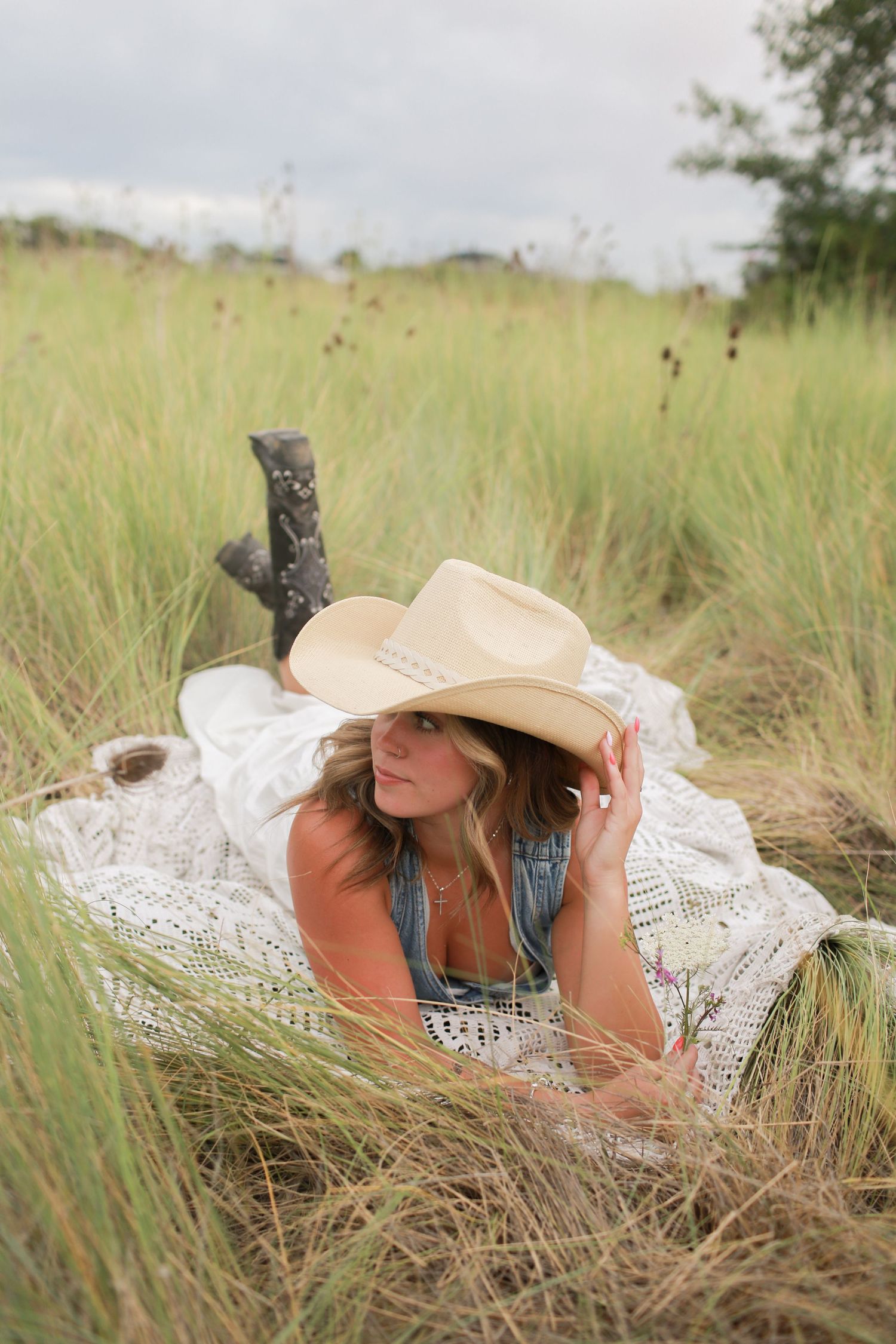 Rustic outdoor portrait in field with mountains and pine trees at dusk.