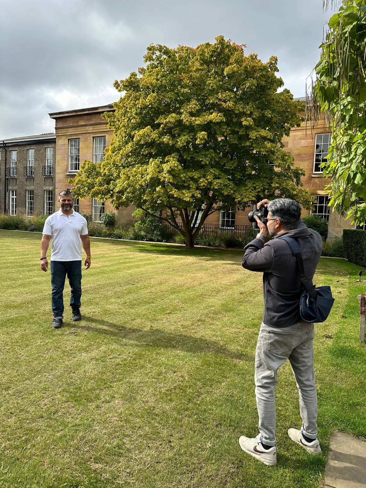 photographer taking a photos of man wearing a burgundy jumper and smiling