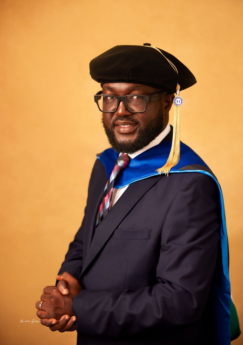 Professional headshot series showing a person in a dark suit and glasses against an orange background.