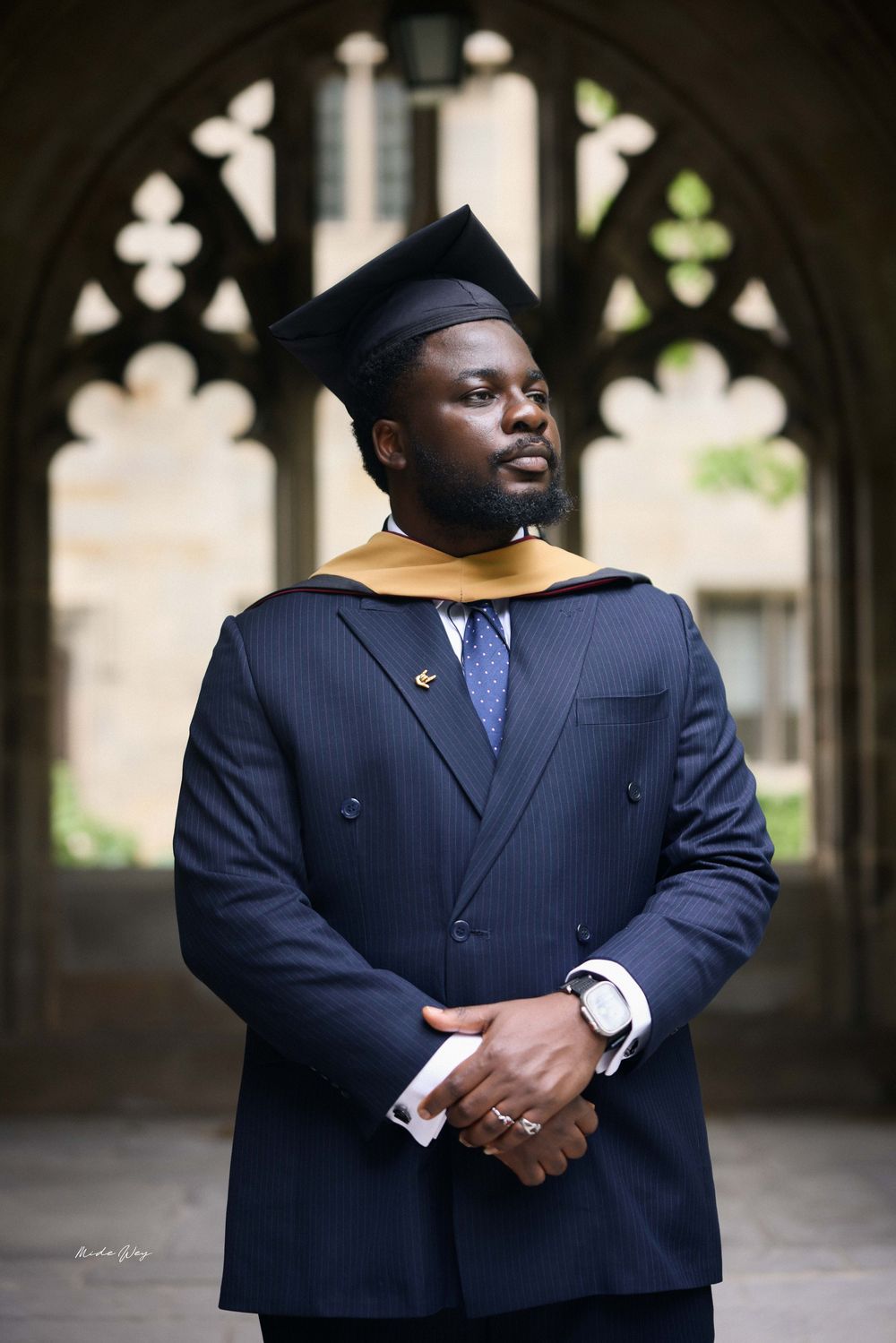 A series of photos showing a person in a navy blue pinstripe suit standing in an elegant archway corridor.