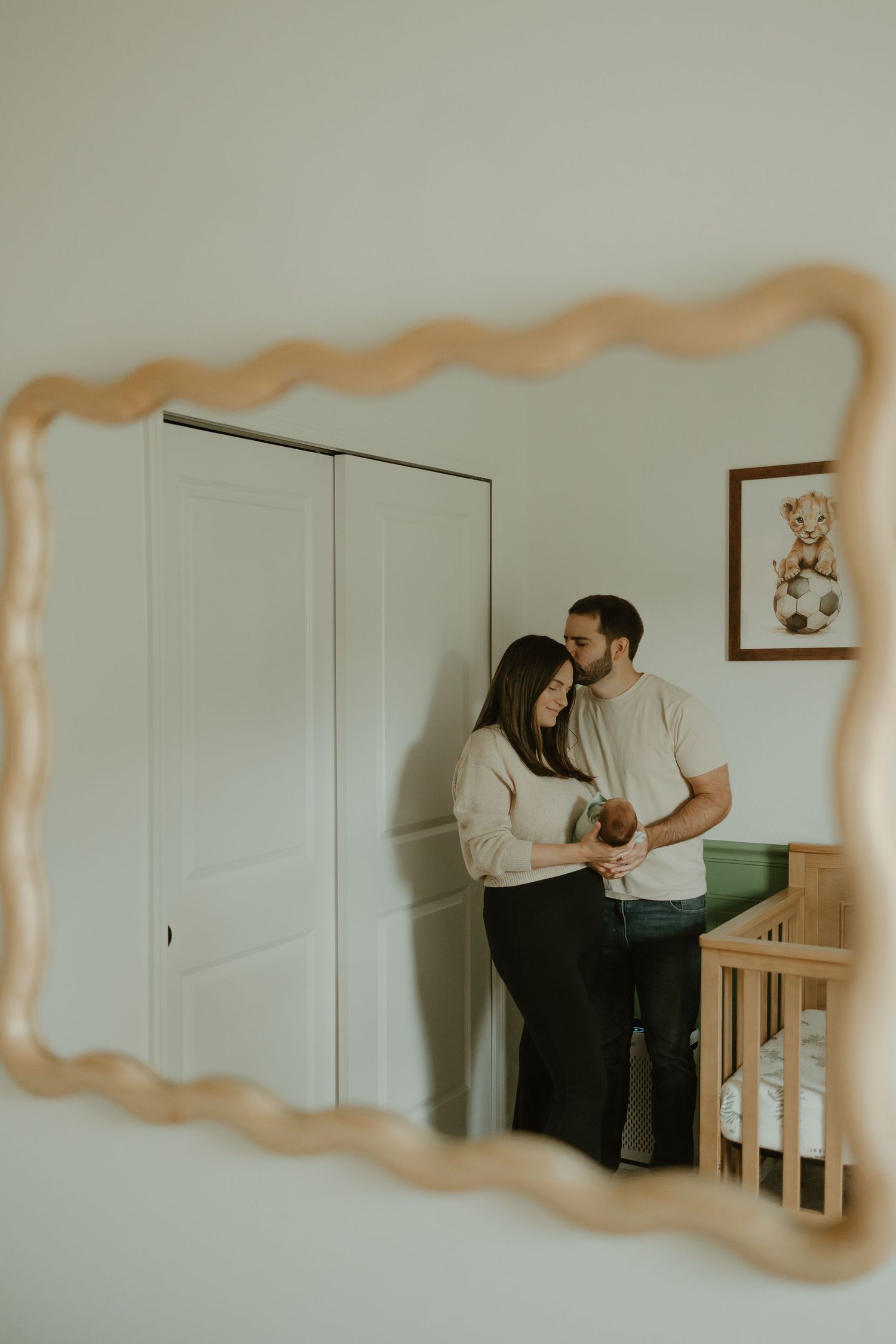 A series of intimate family moments captured in a nursery with white walls and furniture.
