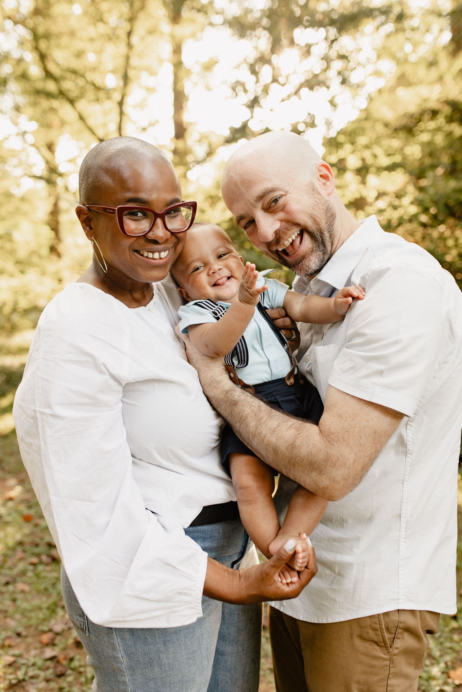 A joyful family moment captured outdoors with golden sunlight filtering through trees.