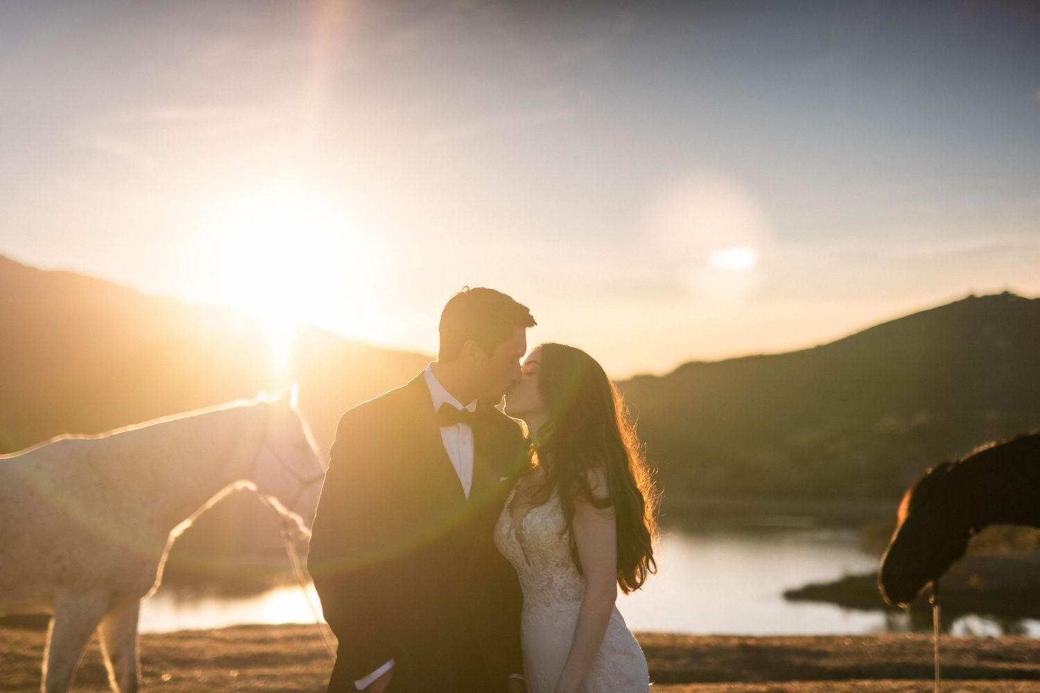 dramatic mountain sunset with golden light streaming through clouds, December wedding with horses, Alisal Ranch, Solvang, California.
