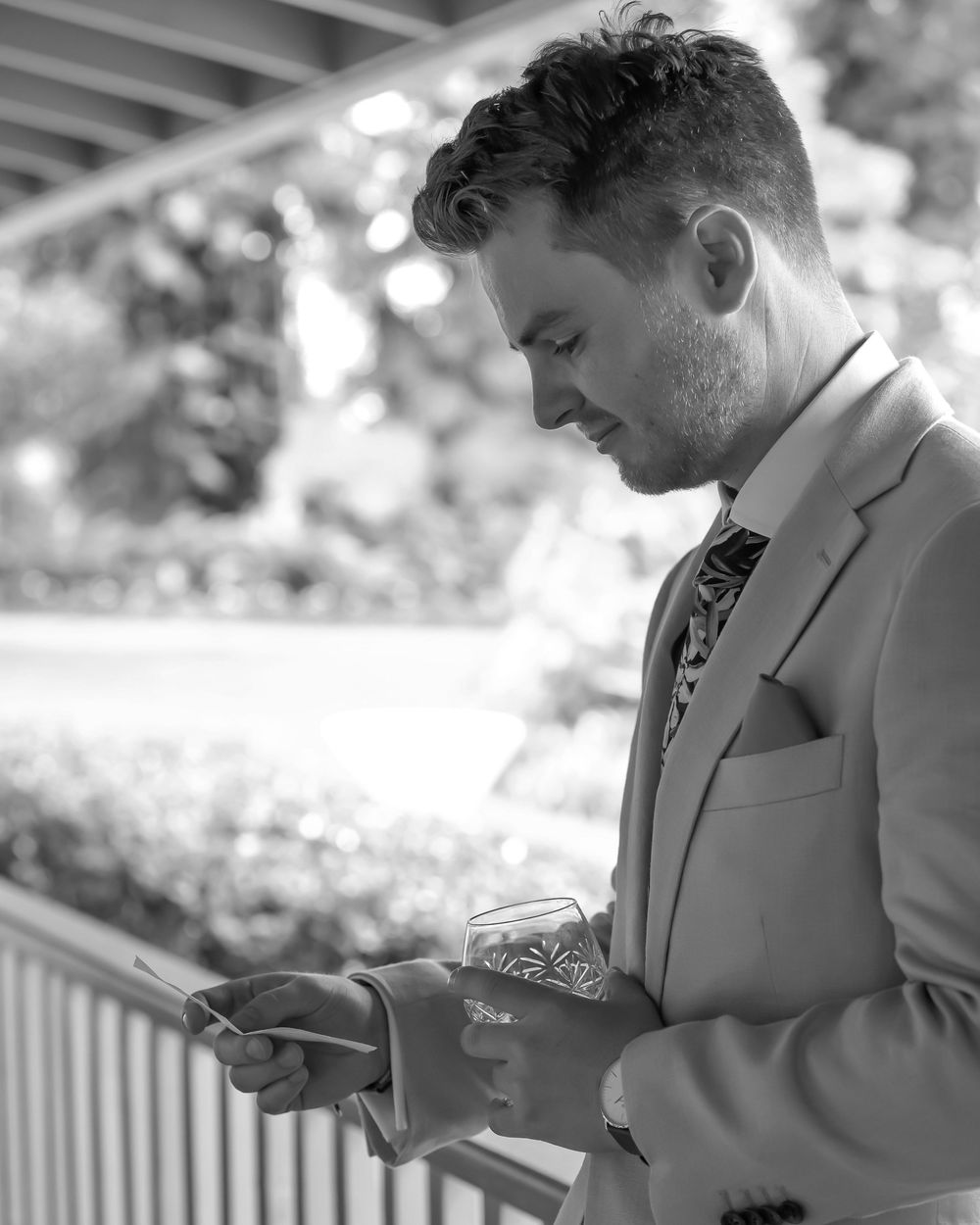A figure in a gray suit stands outdoors and reads from a digital tablet in multiple sequential poses.