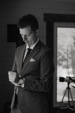 Black and white photos show a groom adjusting his tie and cuffs while getting ready for the wedding ceremony.