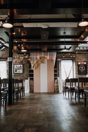 Industrial chic wedding venue with exposed brick walls, pendant lighting, and hardwood floors.
