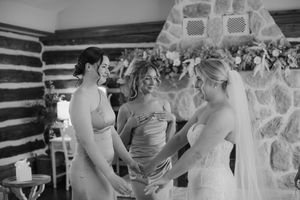 A sequence of black and white photos showing wedding dress preparations with people helping adjust a bridal gown.