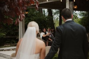 Wedding couple and guests dance together during an outdoor evening reception celebration.