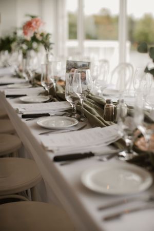 Elegant wedding reception table setting with white linens and delicate floral centerpieces.