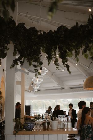 Modern reception venue with hanging greenery and white pillars.