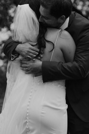 Intimate black and white portrait of newlyweds sharing a tender embrace.