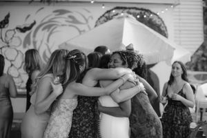 A group of friends share an emotional embrace in a circle.