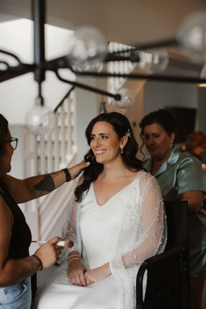Behind-the-scenes moment of wedding preparation with styling happening in natural window light.