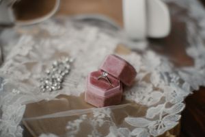 Pink velvet ring boxes displayed on delicate white lace fabric.