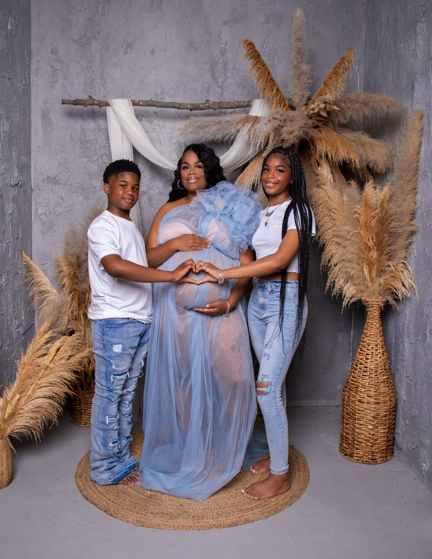 Maternity photoshoot with pampas grass decor and blue flowing dress.