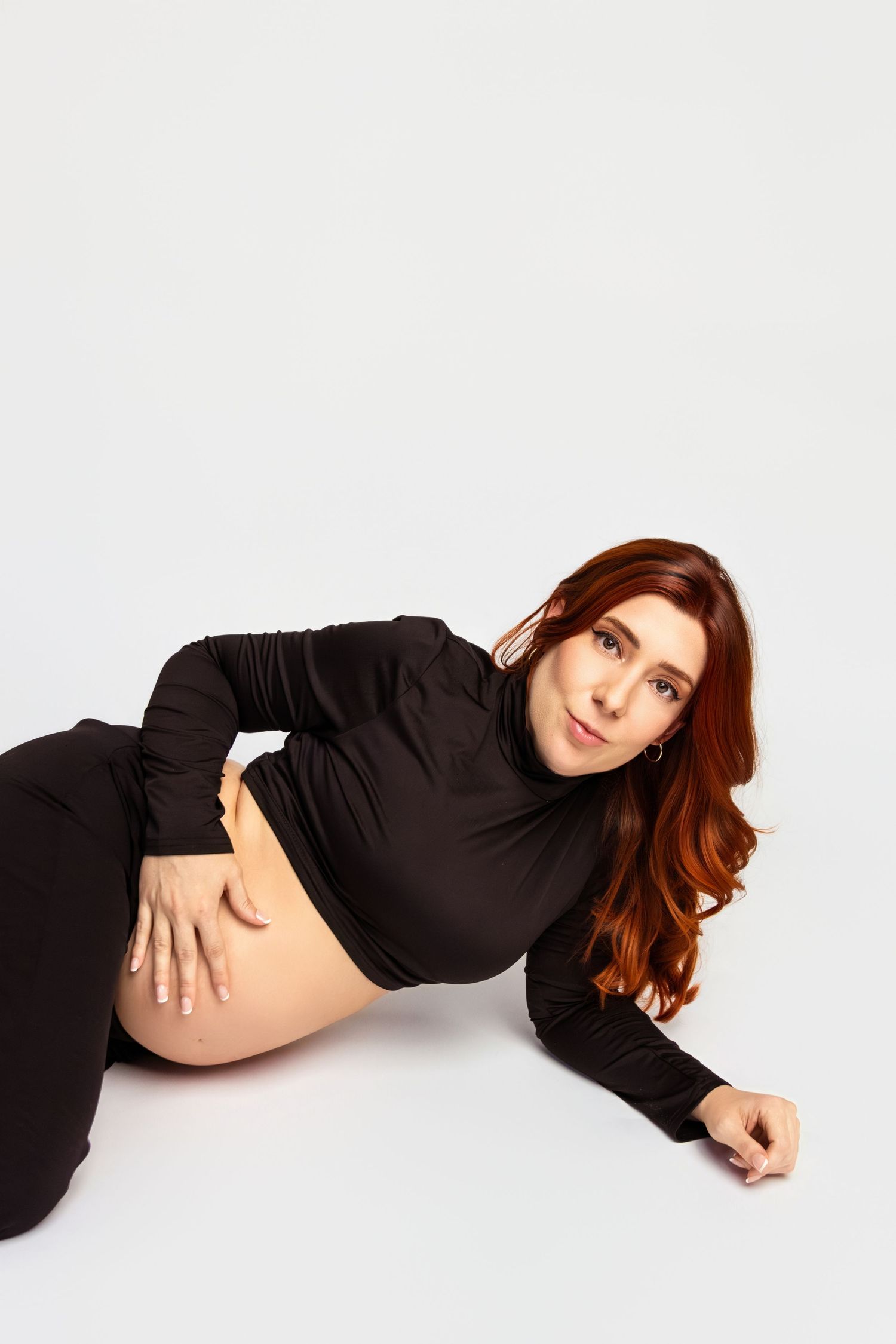 Elegant maternity poses on white backdrop showing pregnant silhouette.