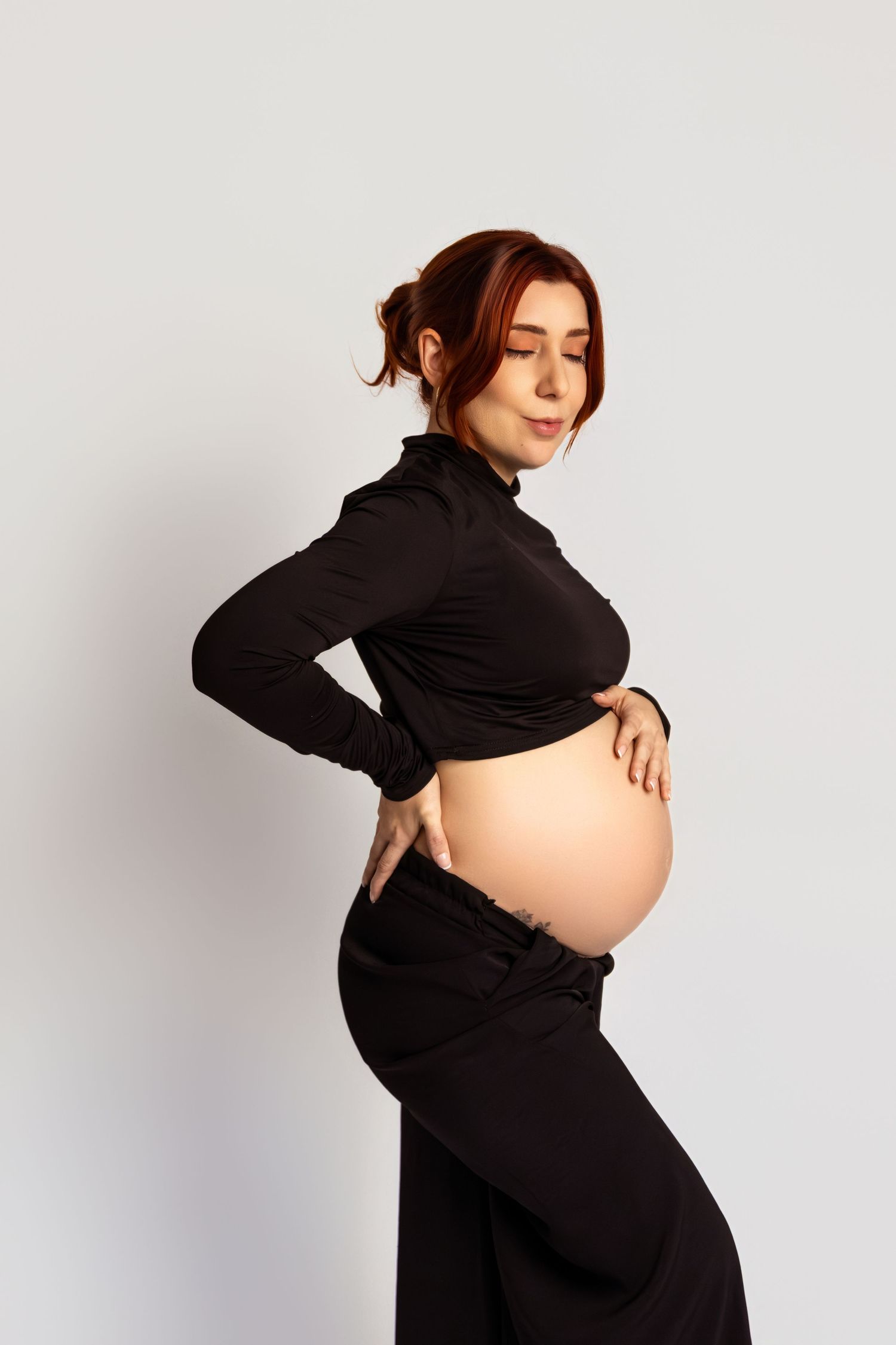 Creative pregnancy photography with dramatic poses in black outfit.
