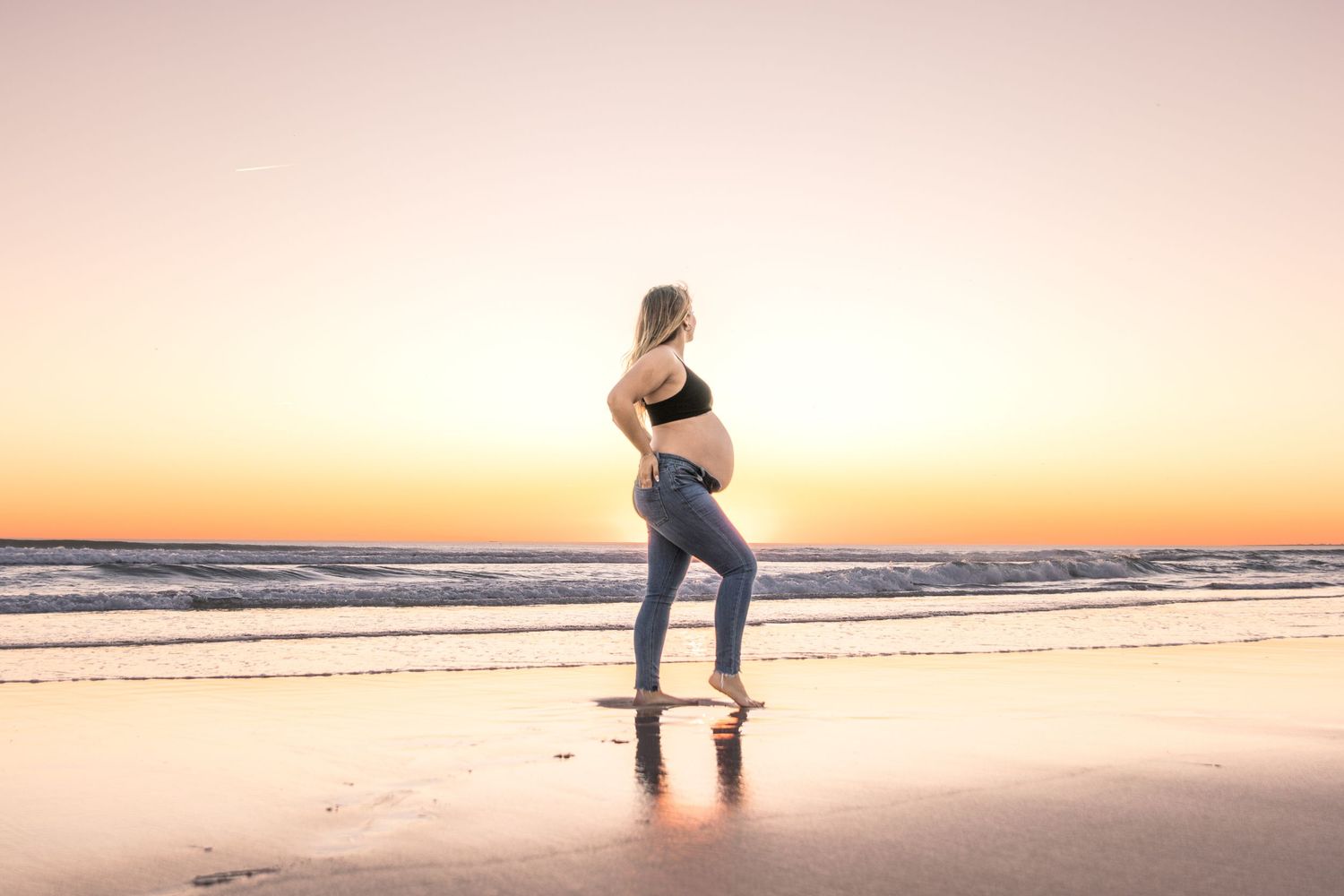 Maternity beach photography session during golden sunset.