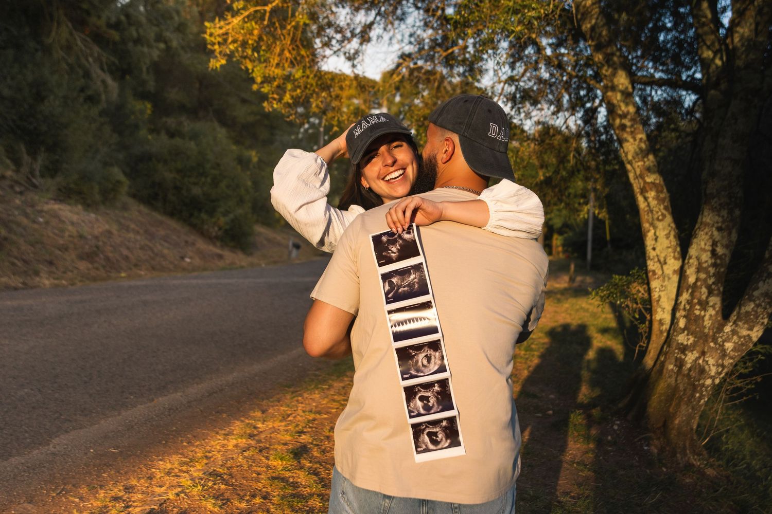 Person in beige sweatshirt standing on autumn road surrounded by trees.